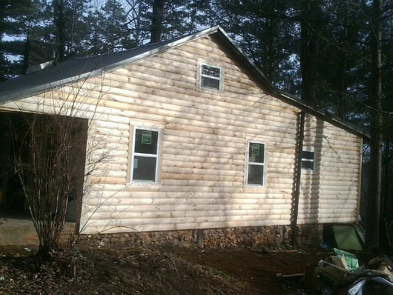 New log siding and dark metal roofing on a gable end in Kenai