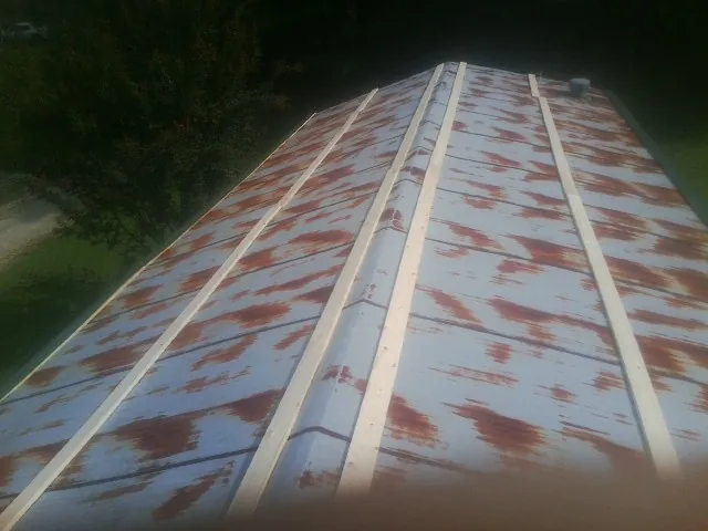 Rusted metal roof panels with new wood purlins before replacement — Storm Damage Roof Repair in Kenai by Roofing Brothers