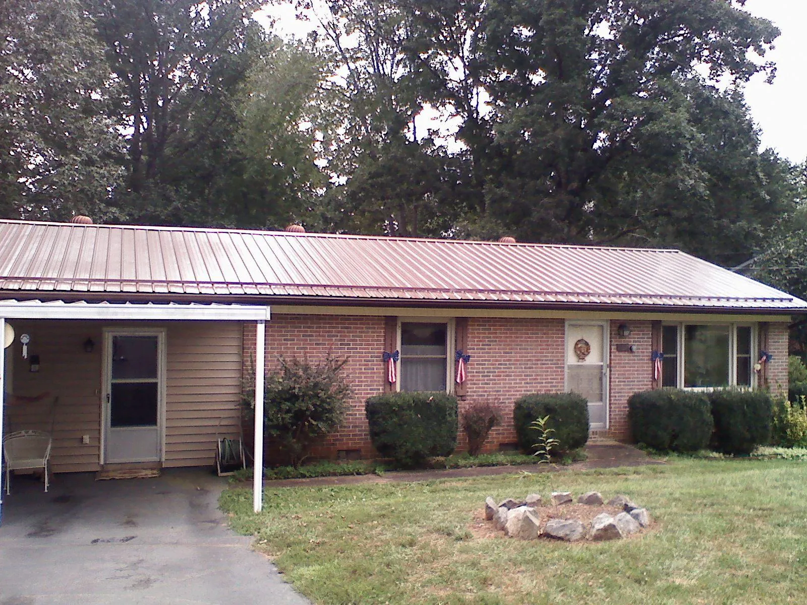Bronze metal roof and carport on a brick ranch home — Roof Repair work by our crew in Kenai